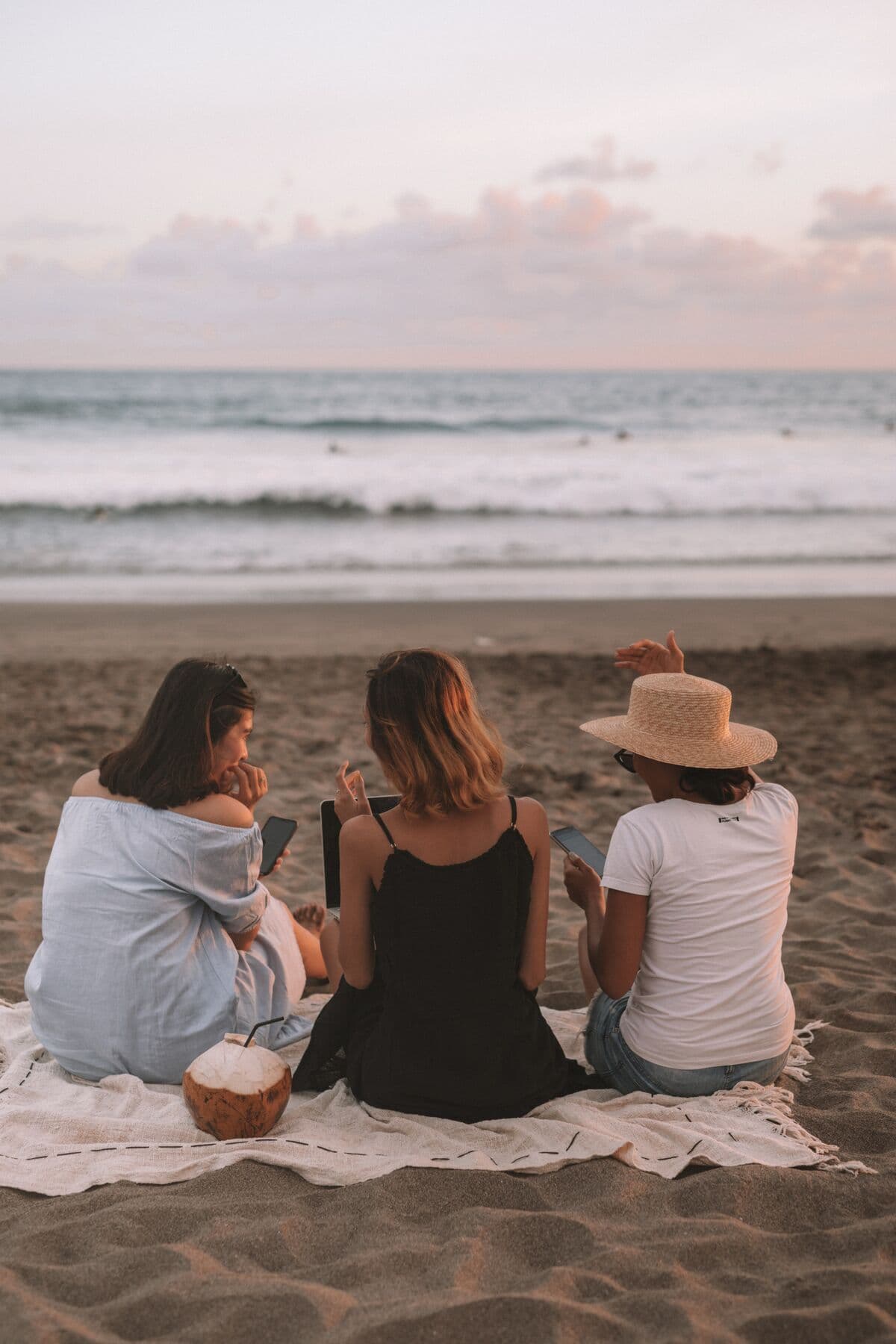 Three friends on a beach at dusk